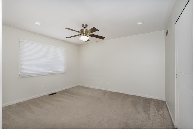 spare room featuring light carpet and ceiling fan