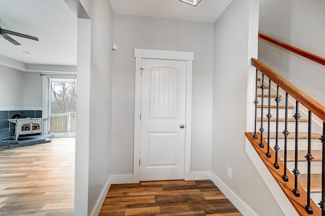 hallway featuring stairway, wood finished floors, and baseboards