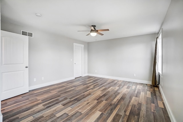 spare room featuring a ceiling fan, visible vents, baseboards, and wood finished floors