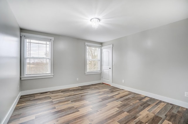 empty room with baseboards and wood finished floors