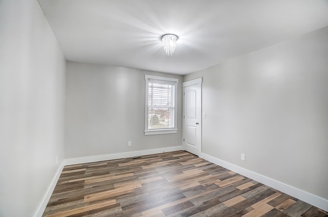 empty room featuring wood finished floors and baseboards