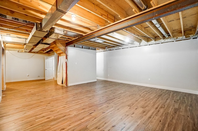 unfinished below grade area with baseboards and wood finished floors