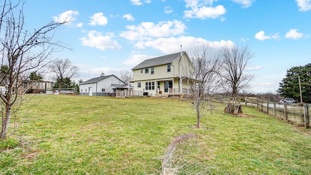 rear view of property with a yard and fence