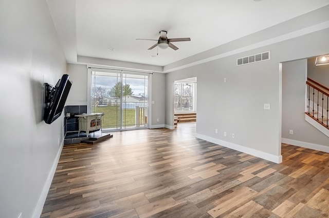 interior space featuring stairway, baseboards, visible vents, and wood finished floors