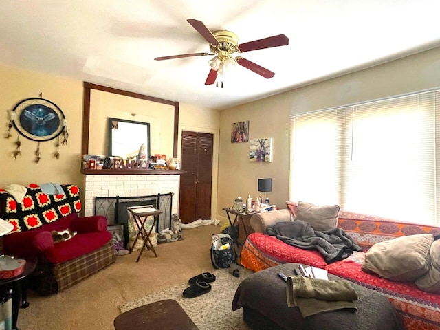 carpeted living area with ceiling fan and a fireplace