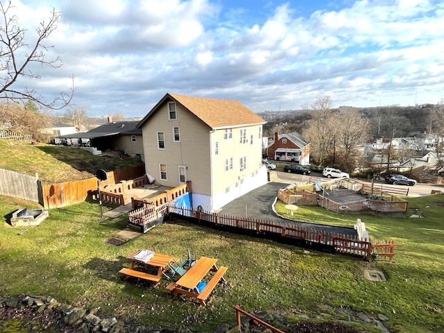 back of property featuring a fenced backyard, a yard, and a deck