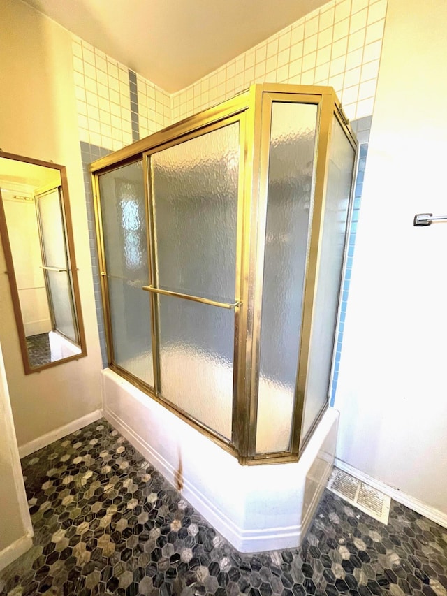 full bathroom with baseboards and enclosed tub / shower combo