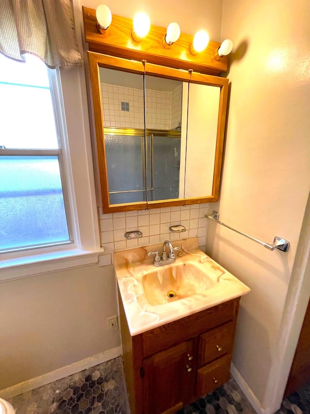 bathroom with backsplash, baseboards, and vanity