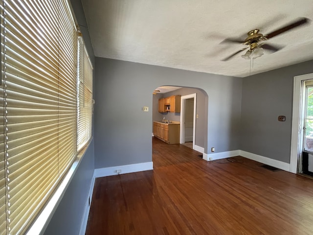 empty room featuring ceiling fan, dark hardwood / wood-style floors, and a textured ceiling