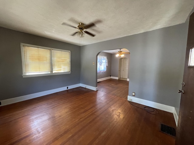 interior space featuring a textured ceiling, dark wood-type flooring, and ceiling fan