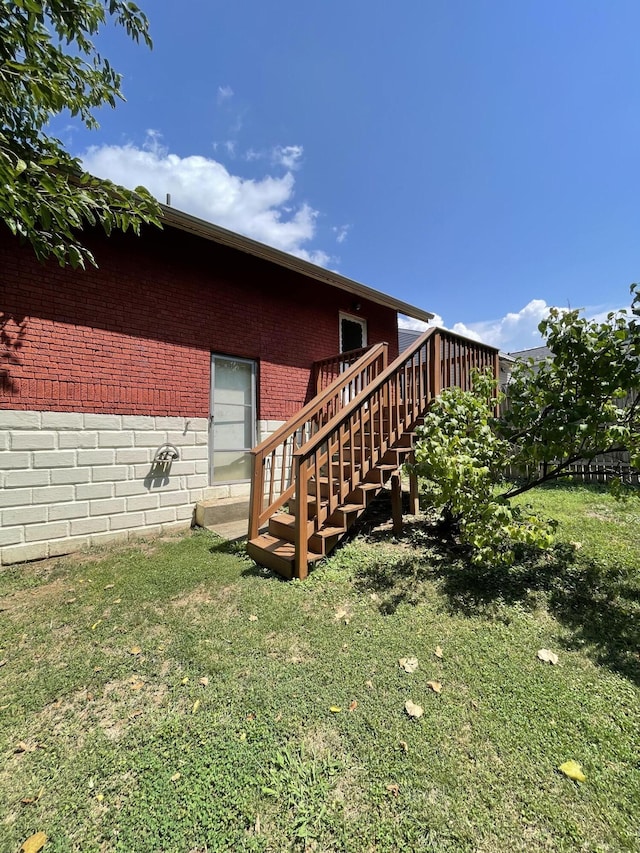 view of side of home with a lawn and a deck