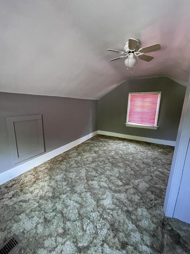 bonus room with ceiling fan, dark colored carpet, and lofted ceiling