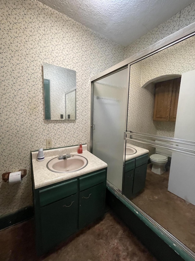 bathroom with toilet, vanity, and a textured ceiling