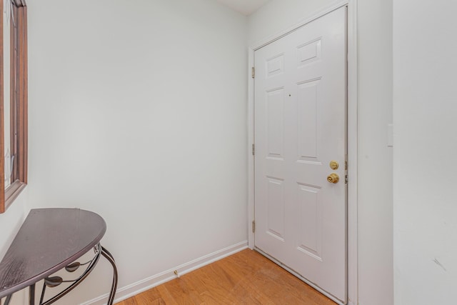 doorway featuring light wood-style flooring and baseboards