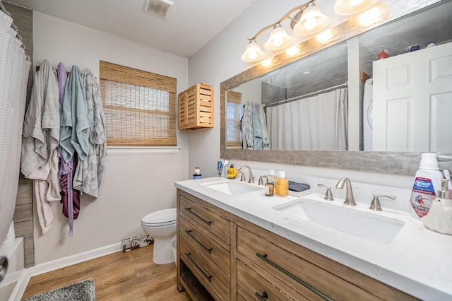 bathroom featuring vanity, hardwood / wood-style flooring, toilet, and a shower with shower curtain