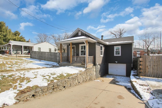 view of front of house featuring a garage, covered porch, and concrete driveway