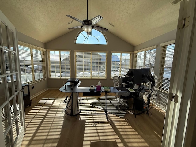 sunroom featuring a healthy amount of sunlight, vaulted ceiling, and ceiling fan