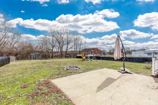 view of yard with fence, a playground, and a patio