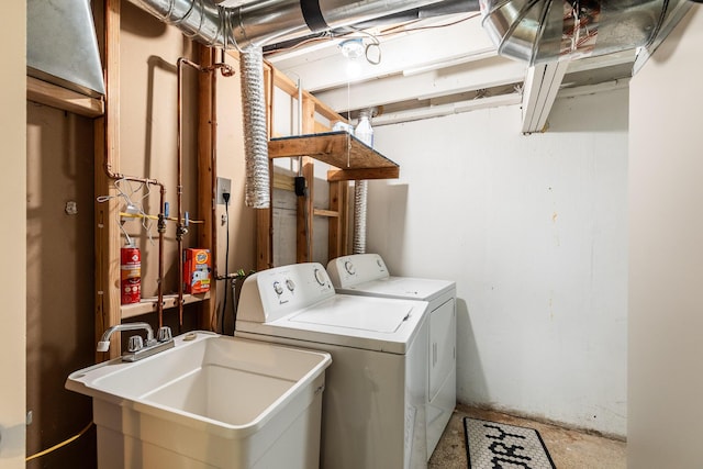 washroom with laundry area, a sink, and washer and dryer