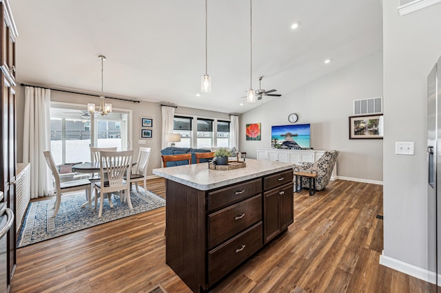 kitchen with a center island, dark brown cabinetry, dark wood-type flooring, and decorative light fixtures