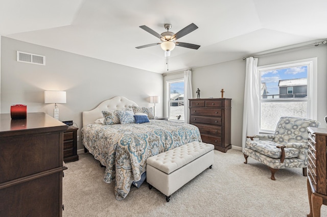 bedroom featuring ceiling fan, vaulted ceiling, multiple windows, and light carpet