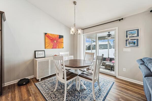 dining room featuring vaulted ceiling, dark hardwood / wood-style flooring, and a chandelier