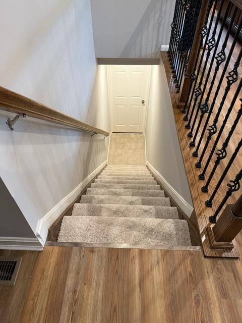 stairs featuring hardwood / wood-style floors