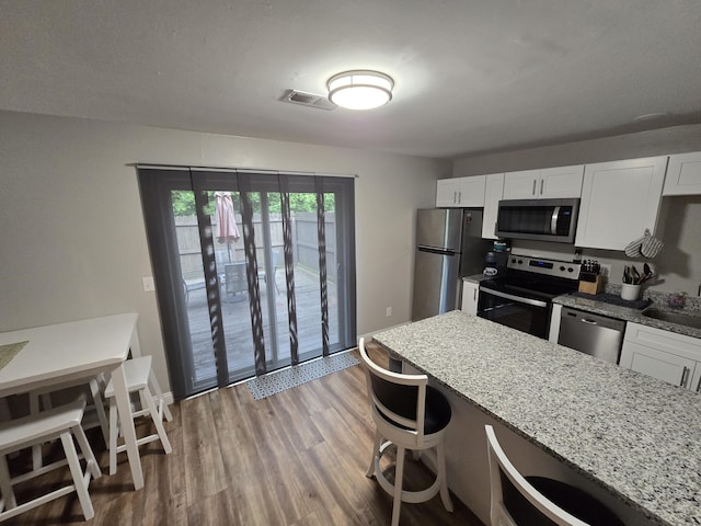 7013 Curtis Way Unit 7013, Florence, KY 41042 - kitchen featuring appliances with stainless steel finishes, white cabinets, light stone counters, and wood finished floors