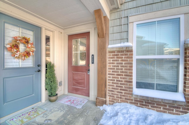 entrance to property featuring brick siding