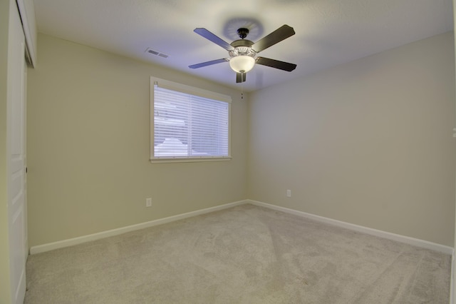 unfurnished room with baseboards, visible vents, and light colored carpet