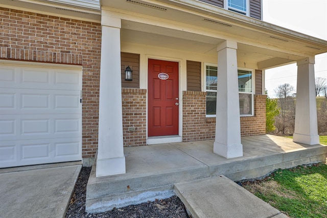 doorway to property featuring brick siding and covered porch