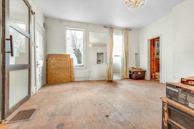 misc room with an inviting chandelier, light wood-style flooring, and visible vents