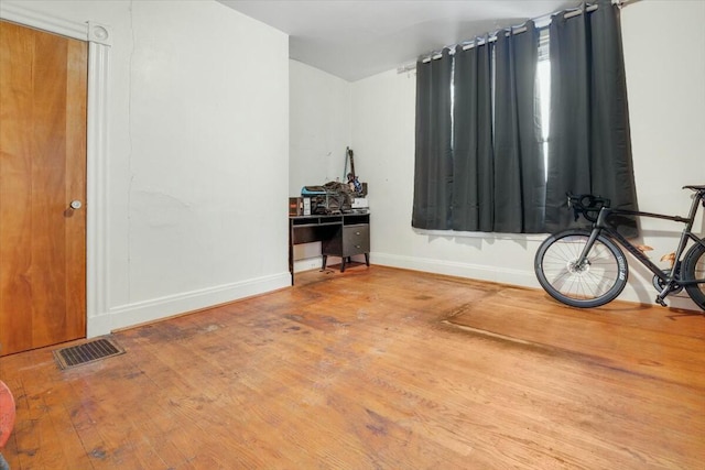 miscellaneous room featuring wood finished floors, visible vents, and baseboards