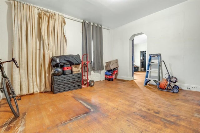 interior space featuring arched walkways and wood finished floors