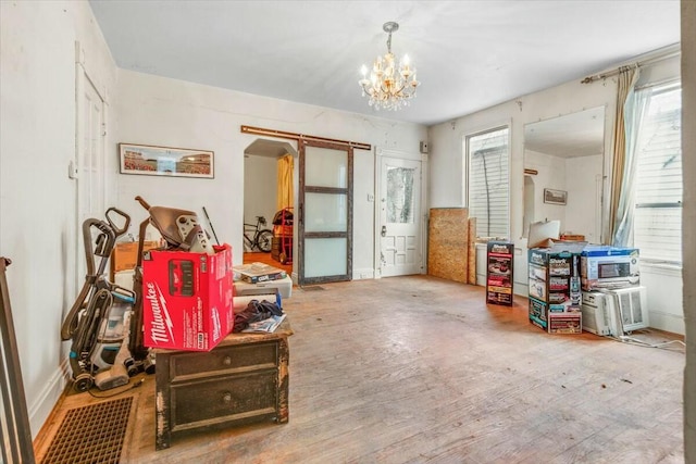 misc room featuring arched walkways, baseboards, wood finished floors, and an inviting chandelier