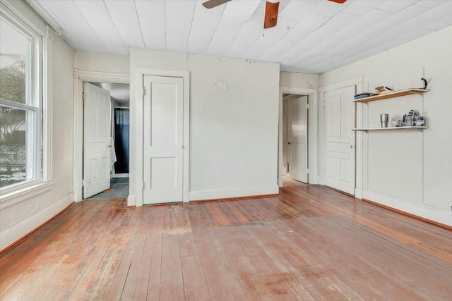 unfurnished bedroom featuring ceiling fan, baseboards, and wood finished floors