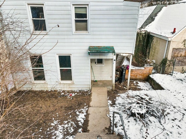 view of snow covered rear of property