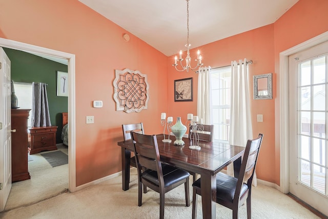 dining space with light carpet, baseboards, a chandelier, and lofted ceiling