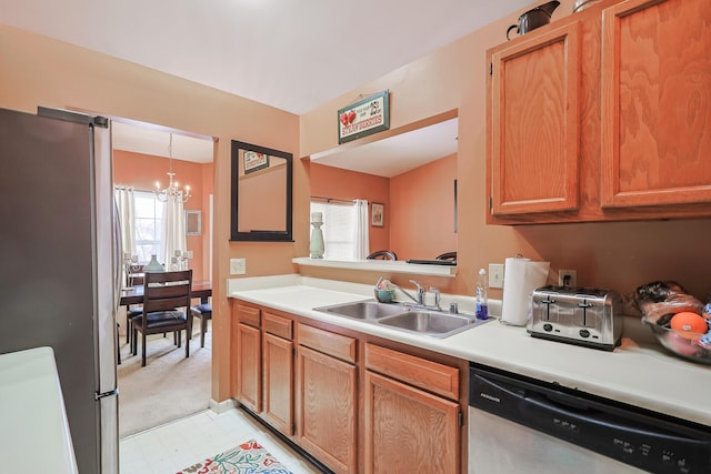 kitchen featuring a notable chandelier, light floors, light countertops, appliances with stainless steel finishes, and a sink