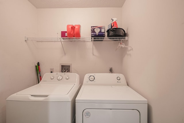 laundry room featuring laundry area, a textured ceiling, and washing machine and clothes dryer