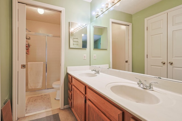 full bathroom with double vanity, a stall shower, and a sink