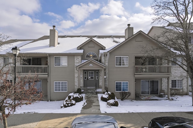 view of front of home featuring a balcony and a chimney