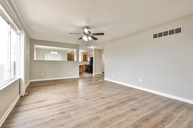 2041 Lafitte Ct, Union, KY 41091 - interior space with ceiling fan with notable chandelier, a textured ceiling, visible vents, light wood-style flooring, and baseboards