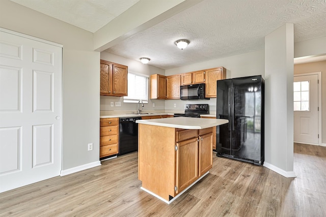 2041 Lafitte Ct, Union, KY 41091 - kitchen with a sink, black appliances, light wood finished floors, light countertops, and a center island