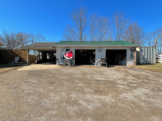 view of front of house with metal roof, an outdoor structure, and a detached garage