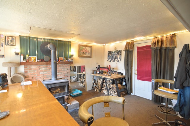 living area featuring dark colored carpet, a wood stove, and a textured ceiling