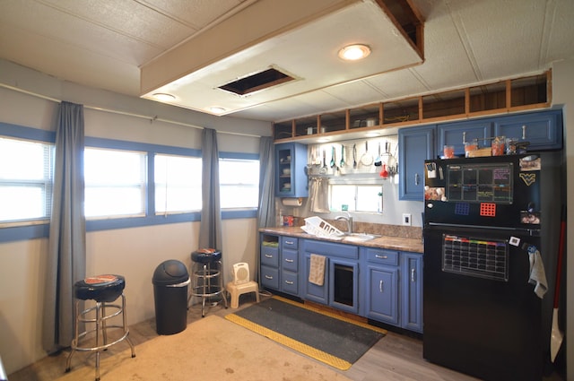 bar with a sink, visible vents, and light wood-style floors