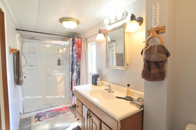 full bathroom with a textured ceiling, a stall shower, and vanity