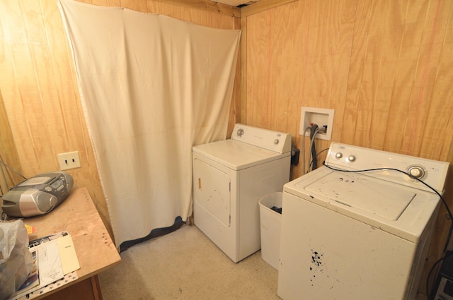 laundry area with washing machine and dryer, laundry area, and wooden walls