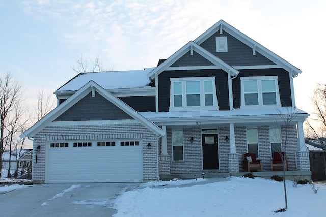 view of front of home with a porch, brick siding, and a garage